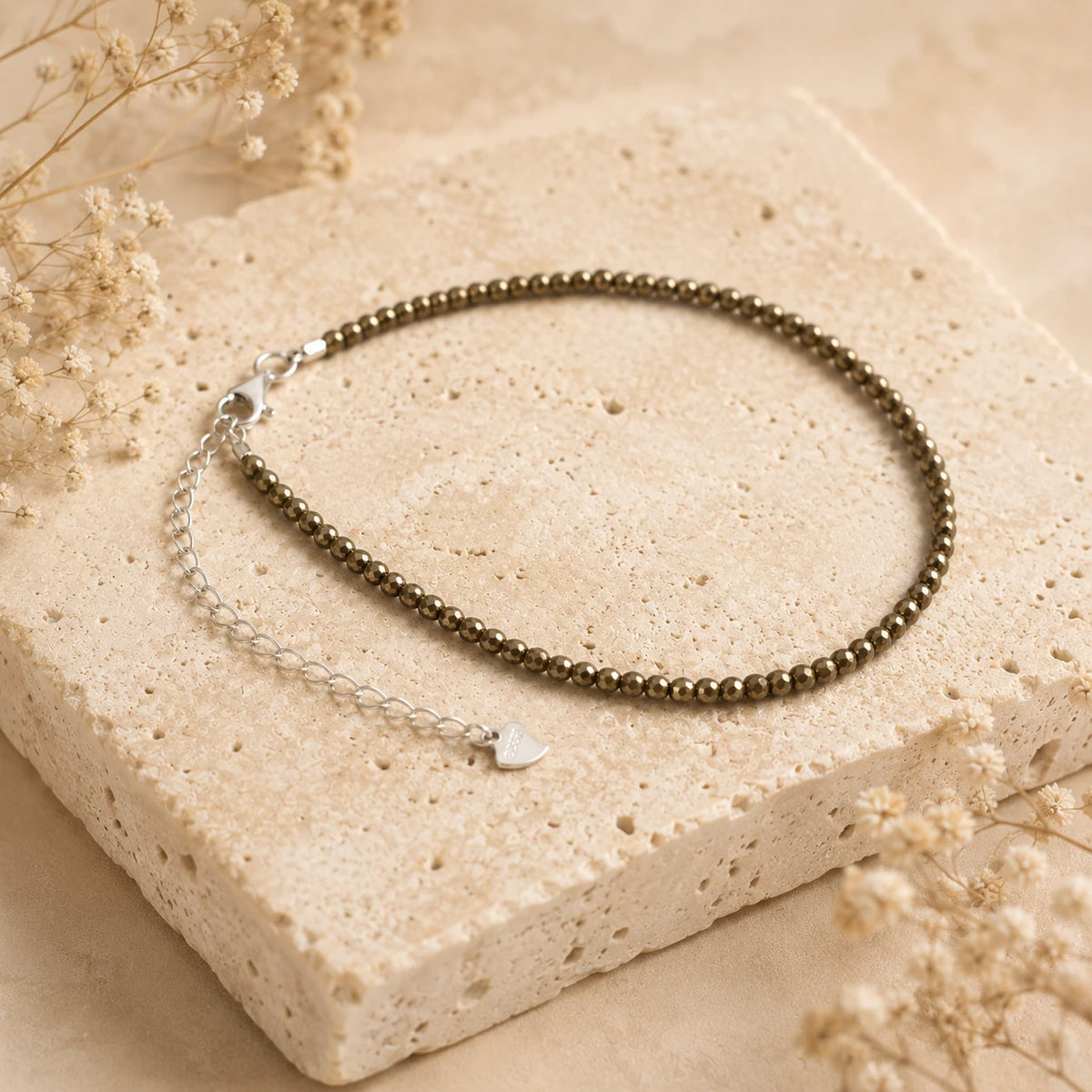 Pyrit Armband mit 925 Silber – Produktansicht auf heller Steinplatte